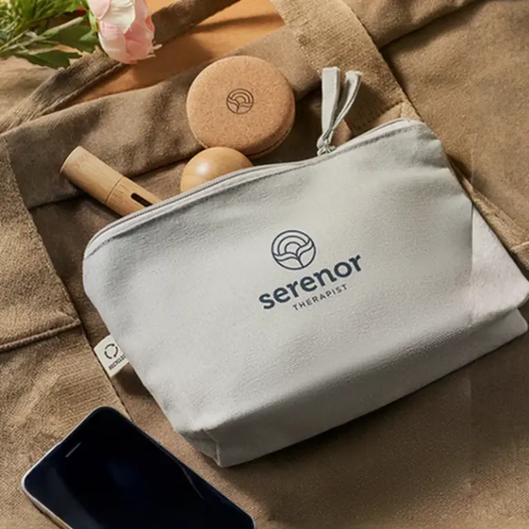 Una bolsa de lona con el logo "serenor therapist" sobre una bolsa de tela con objetos de bienestar.