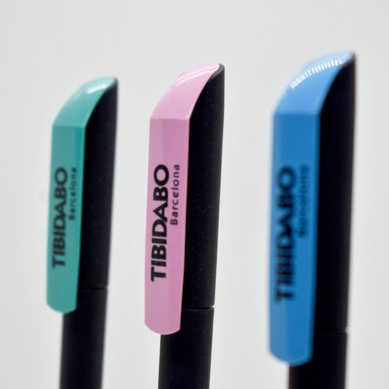 Tres bolígrafos negros con tapas de colores y la marca "Tibidabo Barcelona".