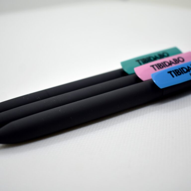 Tres bolígrafos negros con tapas de colores que dicen "Tibidabo".