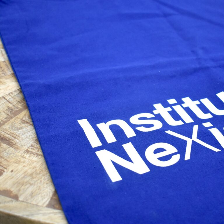 Un paño azul muestra la palabra "Institu" y "Nexi" en letras blancas.