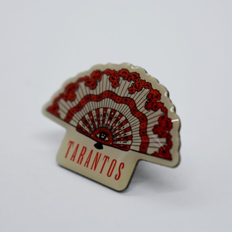 Es un pin con forma de abanico rojo y blanco con la palabra "TARANTOS".