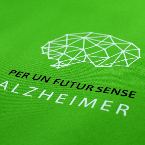 Imagen con texto "Per un futur sense Alzheimer" y un cerebro geométrico blanco sobre fondo verde.