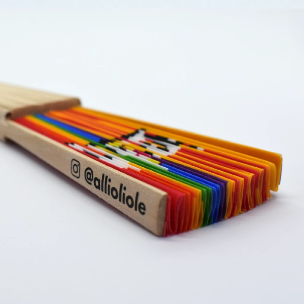 Abanico cerrado con los colores del arcoíris y mango de madera con el logo @allioliole.